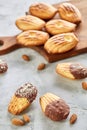 Almond cookies and raw almonds on wooden cutting board over white background, close-up, selective focus. Royalty Free Stock Photo