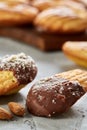 Almond cookies and raw almonds on wooden cutting board over white background, close-up, selective focus. Royalty Free Stock Photo