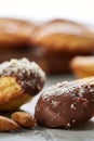 Almond cookies and raw almonds on wooden cutting board over white background, close-up, selective focus. Royalty Free Stock Photo