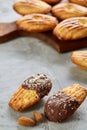 Almond cookies and raw almonds on wooden cutting board over white background, close-up, selective focus. Royalty Free Stock Photo