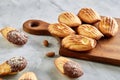 Almond cookies and raw almonds on wooden cutting board over white background, close-up, selective focus. Royalty Free Stock Photo