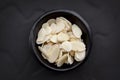 Almond Flakes in Black Bowl over Dark Slate Overhead View. Royalty Free Stock Photo