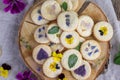 almond floral cookies with edible flowers as violets, speedwell, chamomile, mallow or lemon balm and mint leaves Royalty Free Stock Photo