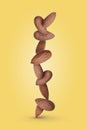 Almond kernels float vertically in equilibrium on a yellow background with shadow. Royalty Free Stock Photo