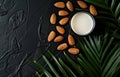 Almond milk and almonds on black background with green palm leaves Royalty Free Stock Photo