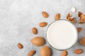 Almond milk in a glass with almond nuts on concrete background. Vegan dairy free plant milk. top view