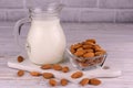 Almond milk in a transparent jug on a white background. Royalty Free Stock Photo