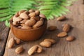 Almond nut in wood bowl on wooden table with green leaf decoration background Royalty Free Stock Photo