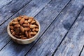 Almond nut in wooden bowl on wood table background, copy space