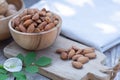 Almond nut in wooden bowl on wood table with green leaf background, copy space Royalty Free Stock Photo