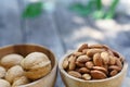 Almond nut in wooden bowl on wood table with green leaf background, copy space Royalty Free Stock Photo