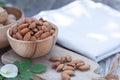 Almond nut in wooden bowl on wood table with green leaf background, copy space Royalty Free Stock Photo