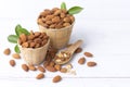 Almond nuts in basket with wood spoon isolated on white wooden background, Almonds are healthiest nuts and one of the best brain