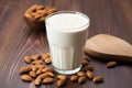 almond protein shake with almonds scattered around on a wooden table