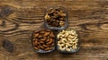 Almond, walnut and cashew in a small plates which standing on a wooden vintage table. Nuts is a healthy vegetarian