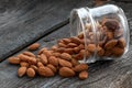 Almonds. Almond Nuts Food in glass jar on wooden table. Raw almonds spilling out of small glass Royalty Free Stock Photo