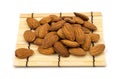 Almonds on a bamboo, on a white background. Royalty Free Stock Photo