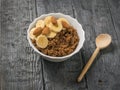Almonds and banana slices in a bowl of quinoa and cocoa porridge.
