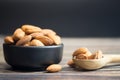 Almonds in black bowl roasted on wooden background Royalty Free Stock Photo