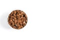 Almonds in a bowl on white background. Isolated, top view.