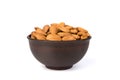 Almonds in a brown clay bowl, isolated on a white background. Front view Royalty Free Stock Photo