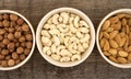 Almonds, cashew and hazelnuts in ceramic bowls on a rustic wooden background. Top view. Healthy concept Royalty Free Stock Photo