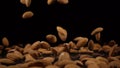 Almonds fall onto a hard black surface