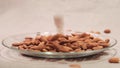 Almonds falling down into glass bowl