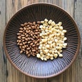 Almonds and Macadamia Nuts in a Decorative Bowl A highresolution image of two types of nuts displayed on a rustic patterned Royalty Free Stock Photo
