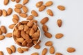 Almonds nut seed in white bowl flat lay top view heap on white background.