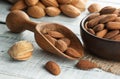 Almonds nuts in dark Brown bowl on rustic vintage wooden table with wooden spoon or scoop. Almond background concept with copy spa