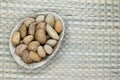 Almonds with the Nutshell in Eco Natural Banana Leaf Plate on Natural Bamboo Mat Surface with Free Space Royalty Free Stock Photo