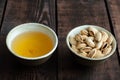 Almonds in nutshell and tea in cup on wooden background Royalty Free Stock Photo