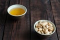 Almonds in nutshell and tea in cup on wooden background Royalty Free Stock Photo