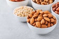 Almonds, pecans, walnuts, pine nuts and hazelnuts in white bowls on grey background. Assortment of nuts. Royalty Free Stock Photo