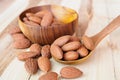 Almonds pour from wood spoon on wooden table