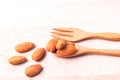 Almonds pour from wood spoon on wooden