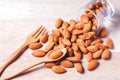 Almonds pour from wood spoon on wooden