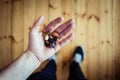 Almonds and raisins in a person's hand over the wooden floor