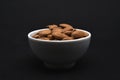 Almonds in a white ceramic bowl. Delicious almonds nuts close-up