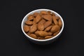 Almonds in a white ceramic bowl. Delicious almonds nuts close-up