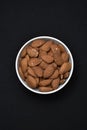 Almonds in a white ceramic bowl. Delicious almonds nuts close-up