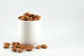 Almonds in a white cup isolated on white background with copy space, close up Royalty Free Stock Photo