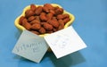 Almonds in yellow dish and blue background Royalty Free Stock Photo