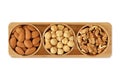 Almons, hazelnuts and walnuts in wooden bowls on white background