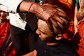 Almora, uttrakhand / India - May 26 2020 : A close of a hand and a head while cutting hairs, indian tradition of cutting hair