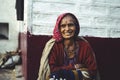 Almora, Uttrakhand - March 2 2021:- Old aged woman sitting with the support of the wall in the sunset wearing indian traditional