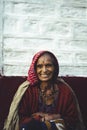 Almora, Uttrakhand - March 2 2021:- Old aged woman sitting with the support of the wall in the sunset wearing indian traditional