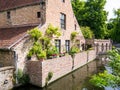 Almshouse in outer wall of Begijnhof, Beguinage, along canal in Bruges, Belgium Royalty Free Stock Photo