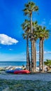 Almunecar, Spain, February 10, 2024. Palm trees and boats on Almunecar beach, in Granada, Spain